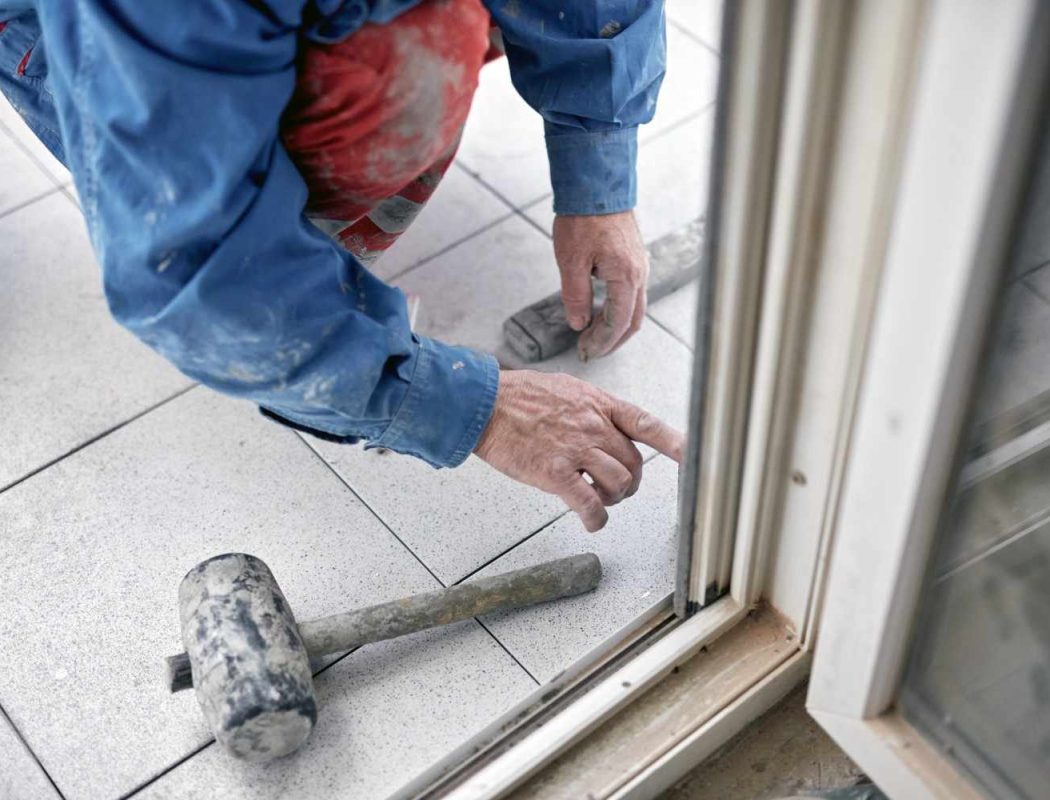 construction-worker-installing-glass-door-on-white-2026-04-13-02-08-15-utc